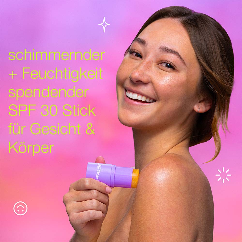 Eine lächelnde Frau trägt den Golden Hour Hydrating SPF 30 Stick vor einem rosa-violetten Hintergrund auf ihre Schulter auf. Der deutsche Text betont den nicht komedogenen Sonnenschutz und die Feuchtigkeitsversorgung für einen strahlenden, glasklaren Teint im Gesicht und am Körper.