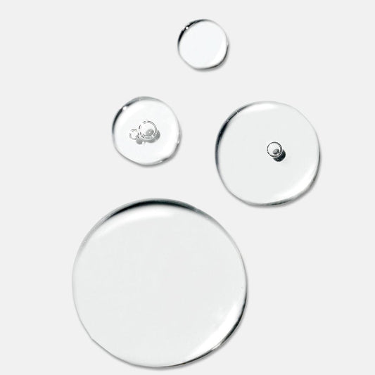 Vier klare Flüssigkeitstropfen unterschiedlicher Größe auf weißem Grund, die der leichten, feuchtigkeitsspendenden Textur des Dermalogica Circular Hydration Serum ähneln.