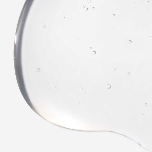 Nahaufnahme eines klaren Gels mit Blasen vor einem hellen Hintergrund, die die glatte Textur von PreCleanse hervorhebt.