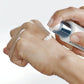 Eine Hand drückt eine kleine Menge einer Creme aus einem Spender auf den Handrücken einer anderen Hand.