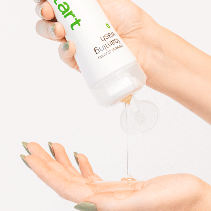Model gibt sich das Breakout Clearing Foaming Wash in die Hand