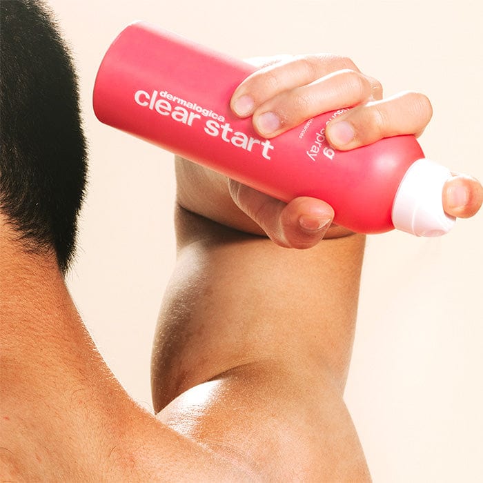 Model zeigt Anwendung des Clarifying Body Sprays auf den Rücken dank 360 Grad Sprühsystem.