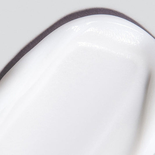 Nahaufnahme der geschmeidigen, weißen MultiVitamin Power Firm Creme mit glänzender Textur auf hellem Untergrund – ideal für die gezielte Pflege der Augenkontur mit reparierenden Vitaminen.