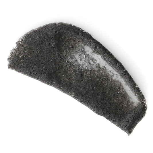 Halbmond-förmiger, schwarzer Konjac-Schwamm auf weißem Hintergrund.
