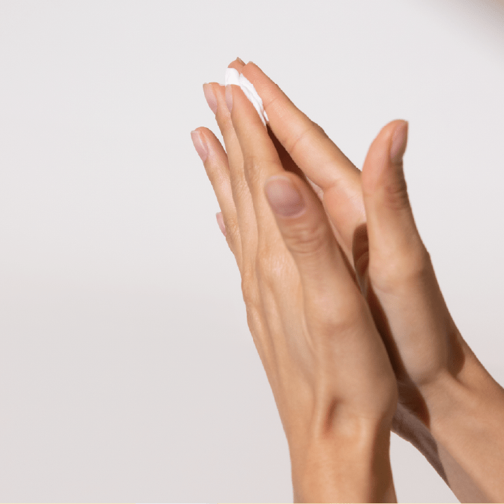 Zwei Hände mit Hautpflege auf dem Handrücken.