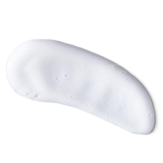 Portion einer weißen, schaumigen Creme auf einem ebenen Hintergrund.