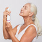 Ältere Frau mit geschlossenen Augen hält Dermalogica-Hautpflegeprodukt nahe ihres Gesichts.
