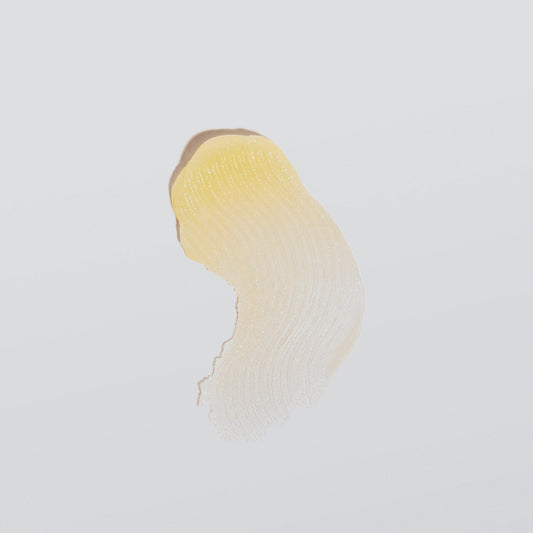 Ein Klecks gelber Flüssigkeit, streifig verrieben auf einer weißen Oberfläche.