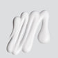 Weiße Creme in streifenartiger Form auf einem einfarbigen Hintergrund.