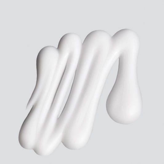 Weiße Creme in streifenartiger Form auf einem einfarbigen Hintergrund.