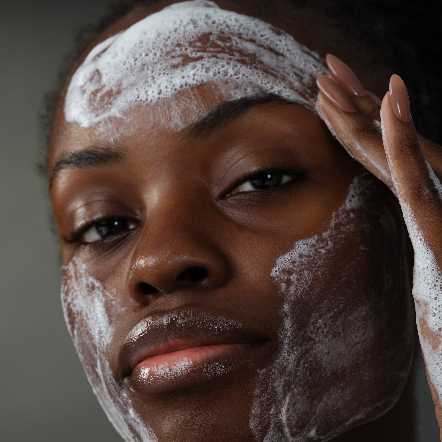 Eine Person verwendet das Skin Transformation Duo und massiert es sanft auf Stirn und Wangen, um eine strahlende Haut zu erhalten.