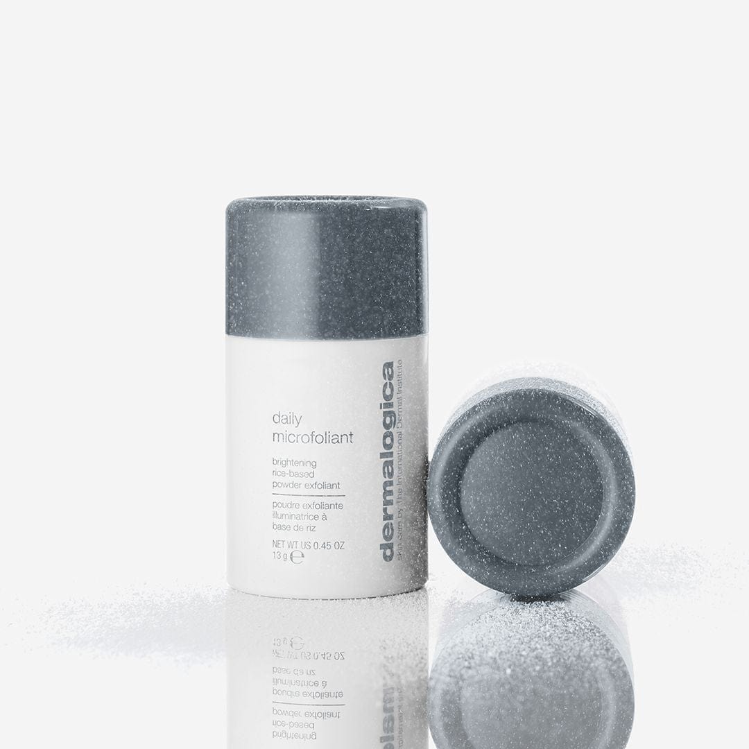 Flasche und seitlicher Deckel von Daily Microfoliant, mit Puder auf einer weißen Oberfläche bestreut