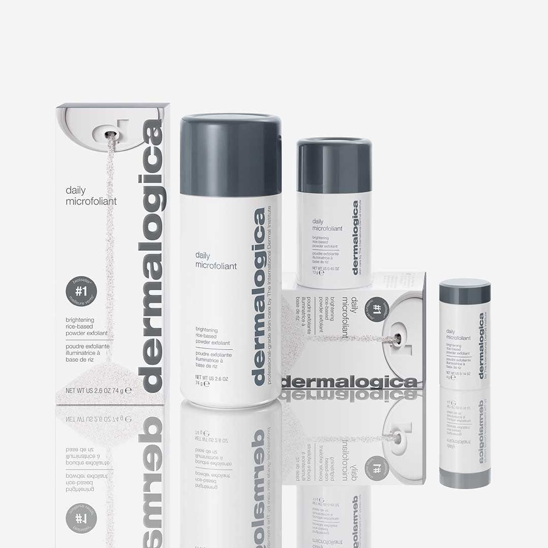Die Dermalogica Daily Microfoliant Gesichtspeeling-Produkte werden elegant auf einer reflektierenden Oberfläche präsentiert und in schlanken Flaschen geliefert. Angereichert mit einem Skin Brightening Complex und Enzympulver versprechen sie strahlende und erfrischte Haut.