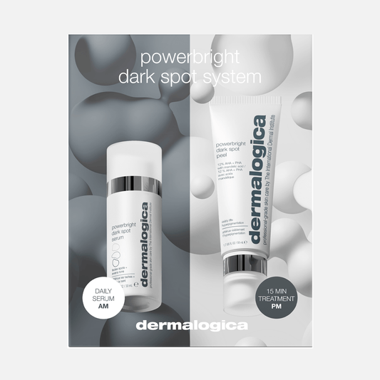 Zwei Powerbright Dark Spot System-Hautpflegeprodukte, ein Tagesserum und eine Dark Spot Peel-Behandlungscreme, die zur Korrektur dunkler Flecken entwickelt wurden, vor einem abstrakten grau-weißen Hintergrund.
