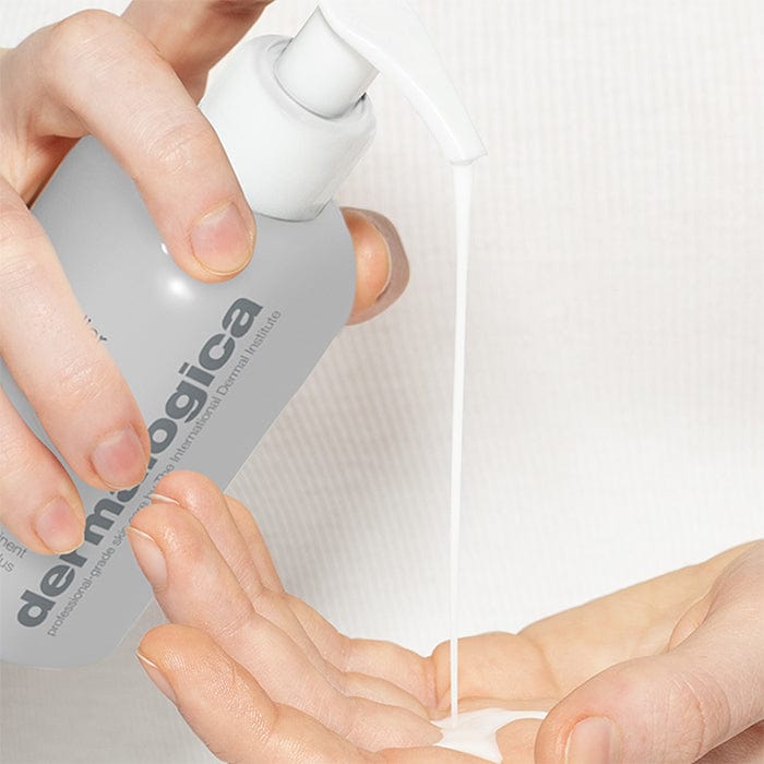 Hände drücken eine Flüssigkeit aus einem Dermalogica-Flaschenspender in eine Handfläche.