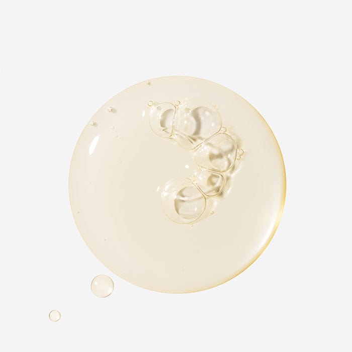 Eine klare, goldfarbene Flüssigkeit mit Luftblasen auf weißem Hintergrund.