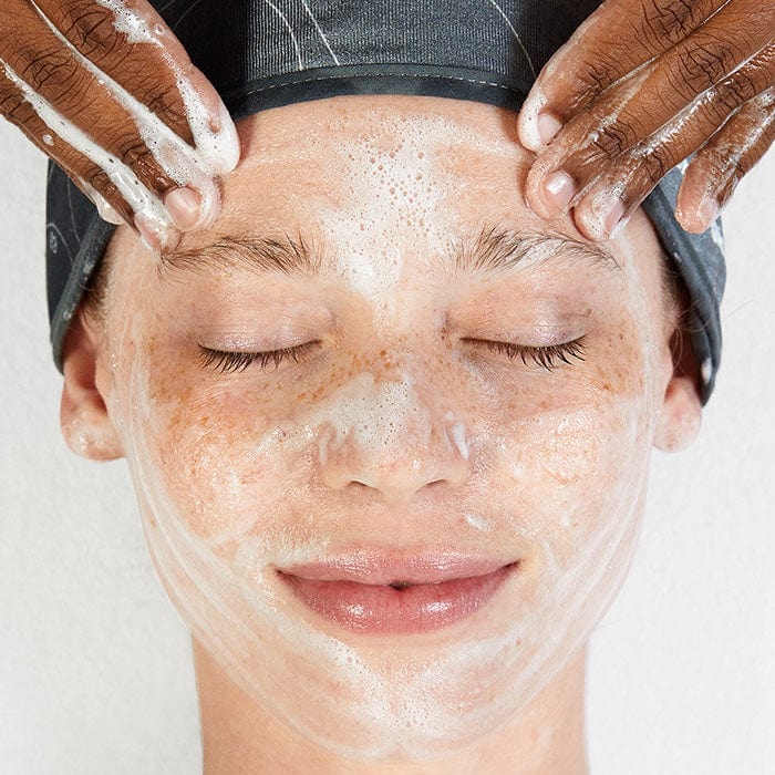 Eine Frau lässt ihr Gesicht mit einem Oil To Foam Total Cleanser waschen.