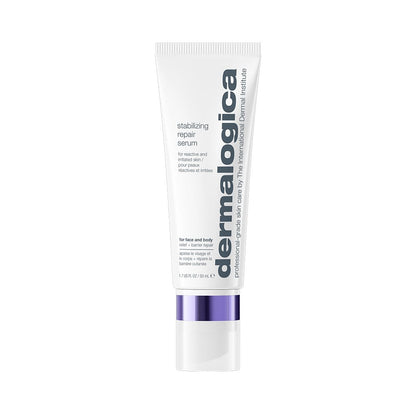 Eine weiße Tube „Stabilizing Repair Serum“ mit kolloidalem Hafermehl und einem violetten Verschluss, das zur Stärkung der Hautbarriere entwickelt wurde, steht aufrecht vor einem schlichten weißen Hintergrund.