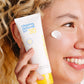 Eine Frau hält eine Tube Clearing Defense SPF30 an ihr Gesicht und tupft etwas davon auf ihre Wange – perfekt für fettige Haut und bietet Breitband-UV-Schutz.