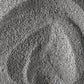 Nahaufnahme einer strukturierten grauen Daily Superfoliant-Puderoberfläche mit sichtbaren Wirbeln und ungleichmäßiger Verteilung, was auf seine potenzielle Rolle bei der Unterstützung der Kollagenproduktion hindeutet.