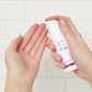 Hände halten eine Flasche Dermalogica Dynamic Skin Recovery SPF50 vor einem hellen Hintergrund.