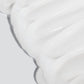 Nahaufnahme des weißen, cremigen Ultra Calming Cleanser mit einer glatten, welligen Textur vor einem hellgrauen Hintergrund - ideal für empfindliche Haut und inspiriert von Dermalogicas sanften Formeln.