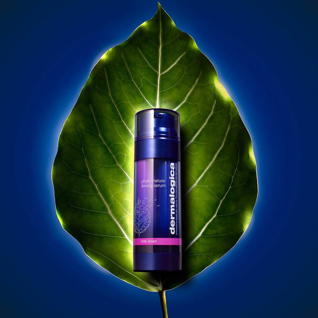 Dermalogica Phyto-Nature Firming Serum, platziert auf einem großen grünen Blatt vor einem blauen Hintergrund.