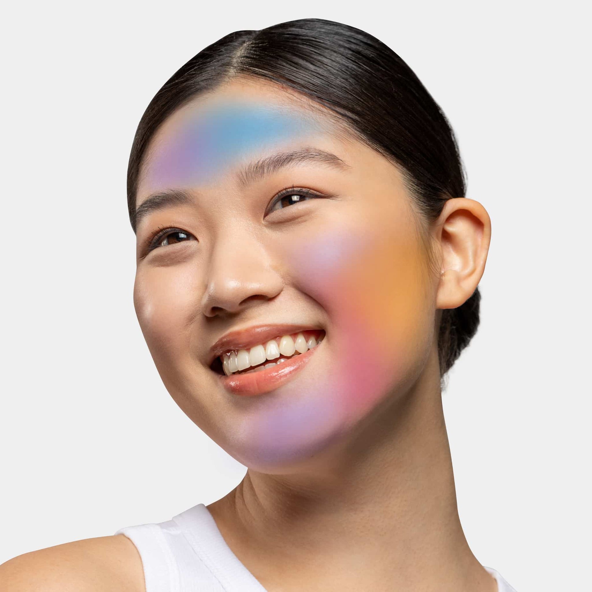 Lächelnde Frau mit farbigem Lichtreflex auf dem Gesicht.
