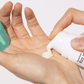 Eine Hand drückt eine Creme aus einer Tube