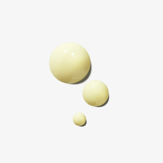 Eine Gruppe gelber Kugeln auf einer weißen Oberfläche, die an Dynamic Skin Retinol Serum | erinnern Anti-Aging-Serum.