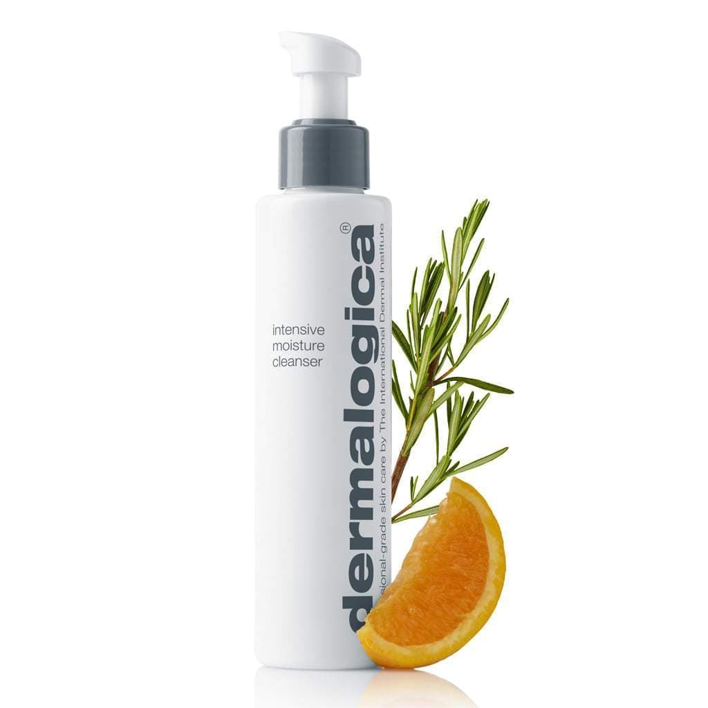 Flasche Dermalogica Intensive Moisture Cleanser mit Pumpspender, flankiert von einem Rosmarinzweig und einem Orangenschnitz auf weißem Hintergrund.