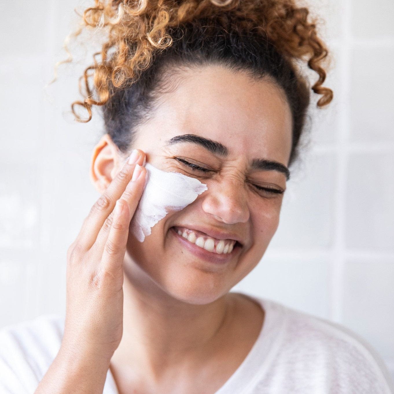 Eine Frau reinigt ihr Gesicht und konzentriert sich dabei auf den T-Zonen-Bereich, um Hautunreinheiten vorzubeugen und zu beseitigen, indem sie die Sebum Clearing Masque 75ml | verwendet Gesichtsmaske.