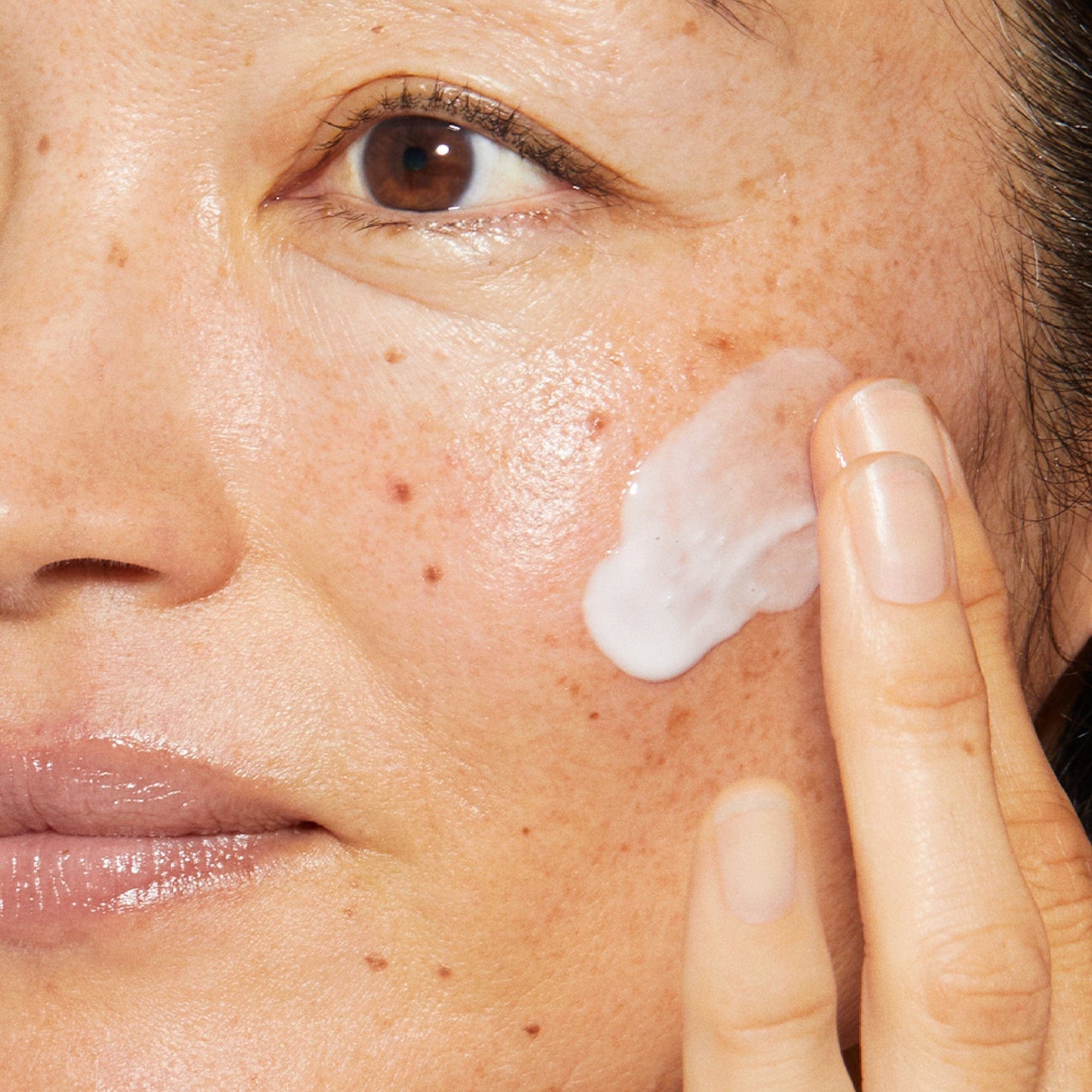 Eine Frau verwendet eine Phyto Nature-Sauerstoffcreme auf ihrem Gesicht, um Hautveränderungen zu bekämpfen.