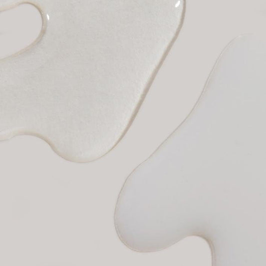 Eine Nahaufnahme eines weißen Pinsels auf einer grauen Oberfläche, verwendet mit PreCleanse 150 ml und Hautbarriere zum Entfernen von Make-up.