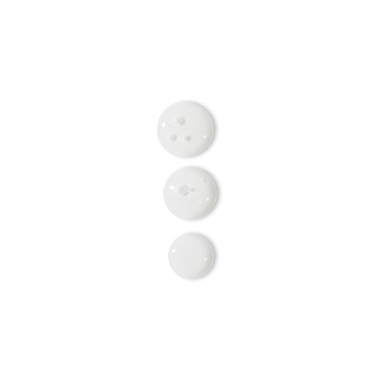 Drei weiße Knöpfe auf einer weißen Oberfläche, die die Hautstruktur verbessern und dem Rapid Reveal Peel 30 ml | unterzogen werden Professionelles Peelingverfahren.