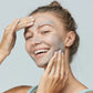 Eine Frau mit Daily Superfoliant | Puder-Peeling im Gesicht, erleben Sie die dreifache Wirkung einer entgiftenden Behandlung.