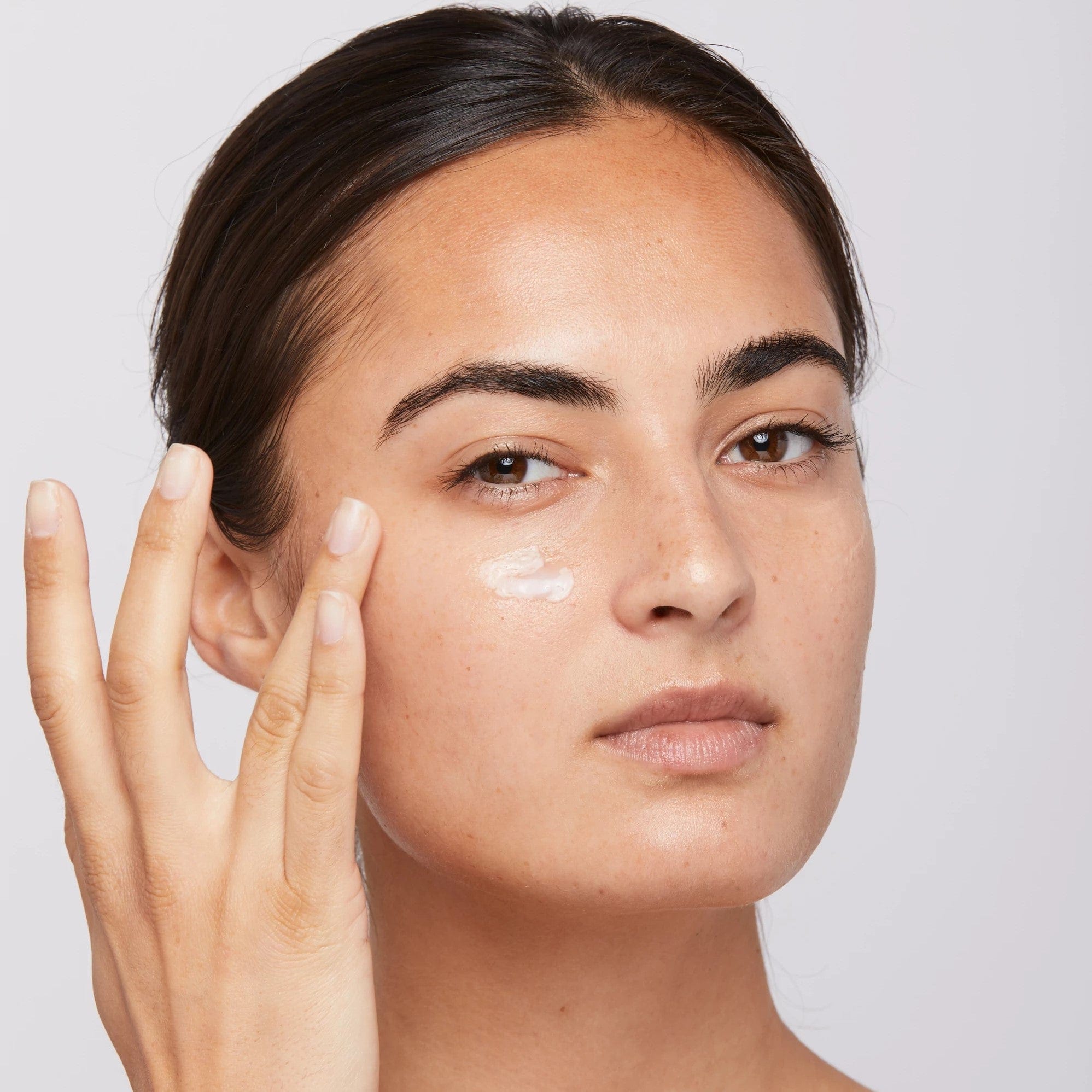 Eine Frau trägt eine 25-ml-Creme „Stress Positive Eye Lift“ auf ihr Gesicht auf.