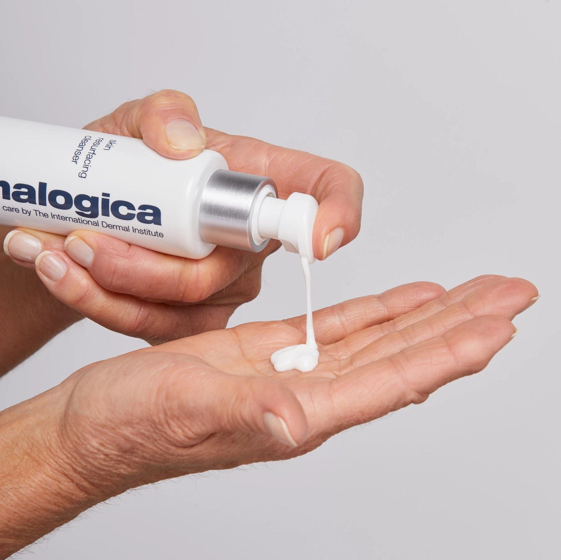 Eine Hand drückt eine kleine Menge einer weißen Creme aus einer Tube der Marke Dermalogica in die andere Handfläche.