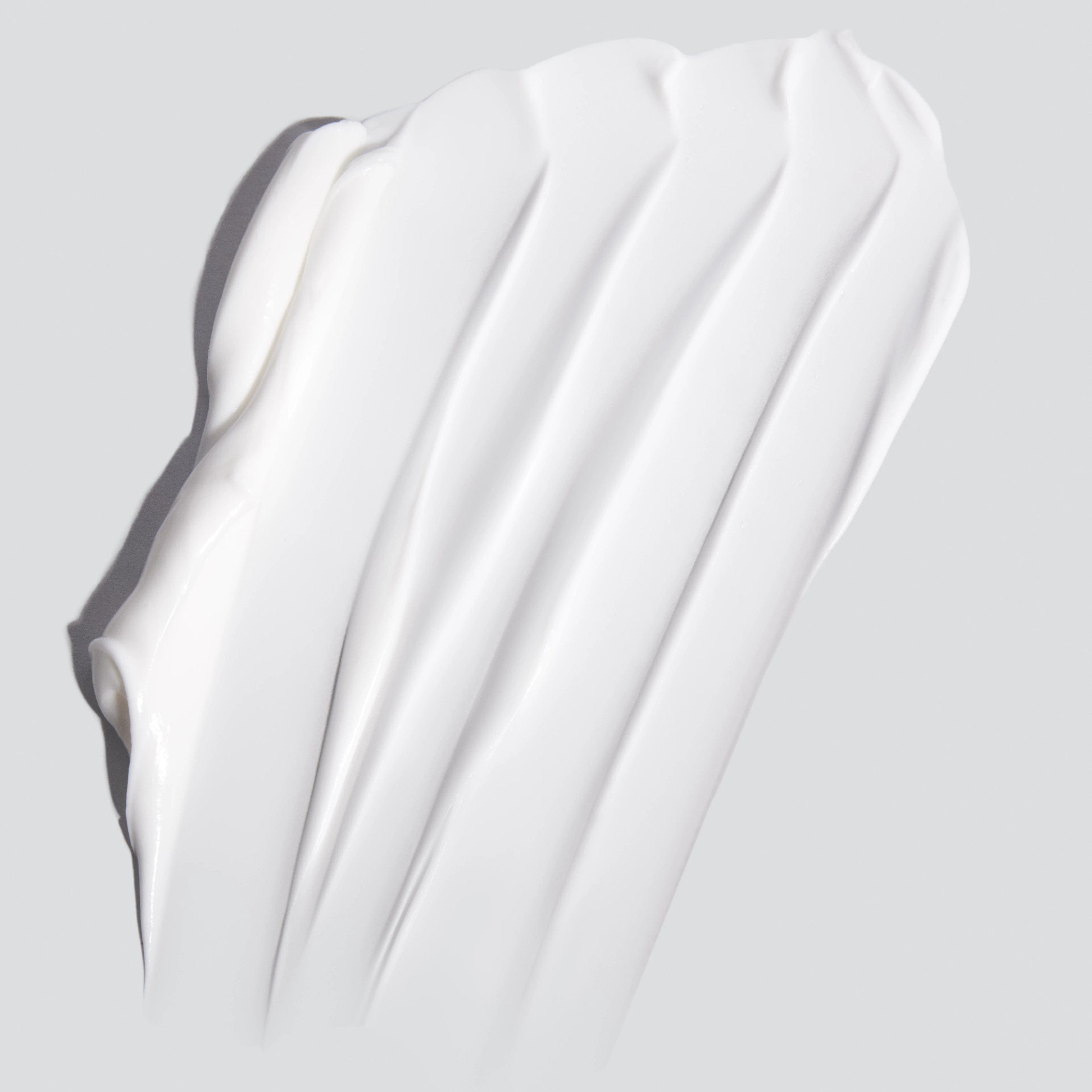 Eine Nahaufnahme einer weißen Hautglättungscreme | Feuchtigkeitspflege-Feuchtigkeitscreme auf grauem Hintergrund.